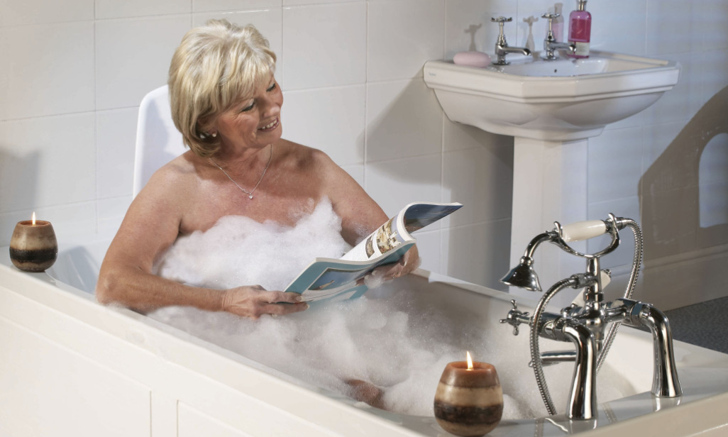 Woman taking a bath using the Archimedes Bath Lift