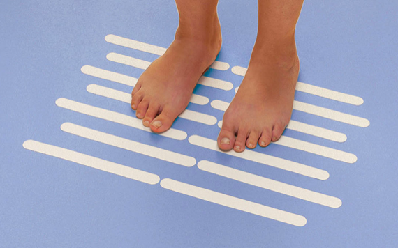 A pair of feet stand on a blue surface with evenly spaced white horizontal stripes painted across it.