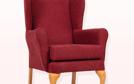 A red chair with large side panels and curved wooden legs stands alone on a simple white background.