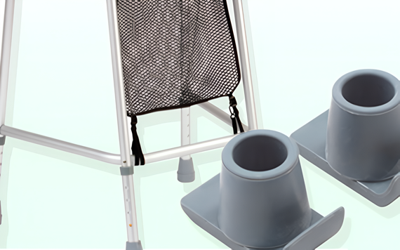 Close-up of a walker with a mesh pouch. Two gray risers for raising furniture are nearby. Light-colored background.