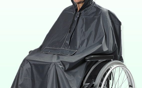 A person in a wheelchair is wearing a black rain poncho that covers both them and the wheelchair, set against a light background.