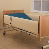 Sidhil hospital bed with light wood frame, blue mattress, full length side rail pads, and remote control, side view.
