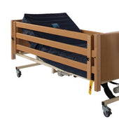 Sidhil Bradshaw hospital bed with side rail height extensions and wheels, side view.