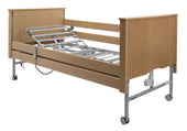 Light oak Sidhil Bradshaw adjustable electric bed with metal rails and wheels, no mattress, side view.