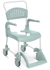 Green shower commode chair with armrests, contoured seat, footrest and four wheels with orange locks, side view.