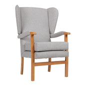 Restwell Jubilee High Seat Chair in stone with wingback, wooden frame and armrests, angled view on white.