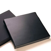 Black wheelchair seat cushion with 2 inch thick vinyl, next to a similar cushion on a light surface, side by side view.