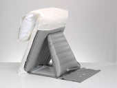 Mangar Handy Pillow Lift with battery airflow pump, folded with white cover for back support on flat surface, front angle.