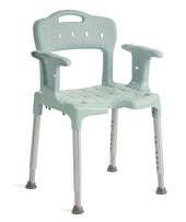 Green Etac Swift shower chair with armrests, height adjustable backrest, drainage holes and non-slip rubber feet, front angle view.