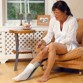 Etac Stocking Aid - Long used by an older woman to put on socks while sitting, in a living room setting, in use.