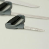 Homecraft Comfort Grip Preparation Knife with grey soft-touch handle on white surface, other knives blurred in background, front view.