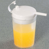 Homecraft Novo Cup with orange liquid, designed for drinking while lying down, on a grey surface, angled view.