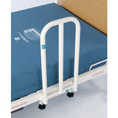 Short grab handle fixed to blue care bed mattress, wooden headboard visible, side view.