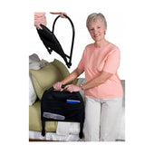 Older woman by bed holding a portable bed rail with storage pockets, inset shows rail folded; bedroom setting, in use view.