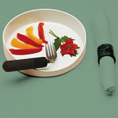 Able2 GripWare High Sided Dish with sliced red and yellow peppers, fork, flower and rolled napkin next to it, side view.