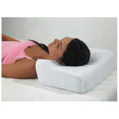 Woman lying on her back with head supported by Harley Designer Pillow, wearing pink tank top, in use side view.