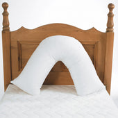 Harley V Pillow on a white mattress with wooden headboard, designed for neck and shoulder support, in use view.