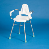 White and grey shower stool with arms and backrest on a blue background, front view.