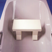 White bath seat with two metal grab bars on each side, shown placed in a bathtub, angled view.