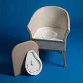 Gordon Ellis Derby Basketweave Commode with removable seat and padded cover on blue background, front view.