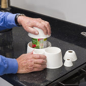Gordon Ellis Spill Not jar opener used to open a can on black kitchen worktop, in use view.