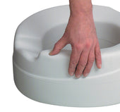 Hand holding Able2 Rehosoft raised toilet seat for accessible seating, close-up view.