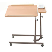 Brown Cefndy split level overbed table with wheels, main wooden top and smaller side platform holding a white cup and saucer, angled view.