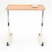 Orion height adjustable table with wooden top, white cup and saucer on upper right corner, front angle view.