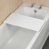 Savanah slatted shower board placed over a bathtub next to a tiled wall and two taps, in use view.