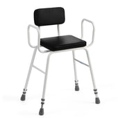 Black perching stool with padded backrest, armrests, white frame and rubber-tipped legs, front angle view.