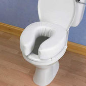 Homecraft Padded Raised Toilet Seat fitted on a white toilet, wood floor and blue walls, side view.