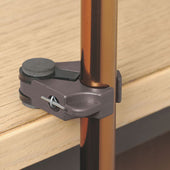 Stick clip holding a walking cane upright on the edge of a table, side view.