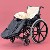 Wheelchair cosy with fleece lining and black and beige cover, on a pink background, front view.