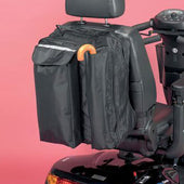 Black waterproof scooter bag with several compartments and crutch holder, attached to a scooter, pink background, rear view.