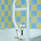 Homecraft Bathtub Grab Rail fixed to tub edge, blue and yellow tiled wall behind, side view.