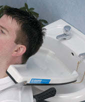 Man resting head on Homecraft Deluxe Hair Washing Tray over sink with water running into basin, in use side view.