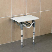 White fold-away shower seat with metal legs fixed to a tiled wall above a grey floor, front view.