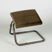 Adjustable padded leg rest with slanted cushioned top and metal frame, shown at an angle view.