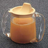 Homecraft Caring Mug with angled handles and beige spout lid, filled with light brown liquid, on a dark surface, front view.