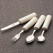Set of four utensils with thick white handles for easier grip, shown on a textured grey surface, top-down view.