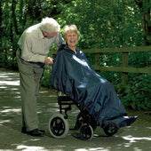 Homecraft Wheelchair Mac without Sleeves worn by an older woman, in use on a wooded path, rear angle.