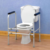 Adjustable toilet surround with metal frame and handgrips, shown against blue wall and wooden floor, front view.