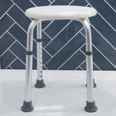 Height adjustable plastic shower stool with metal legs on tiled floor, dark blue herringbone wall background, front angle.