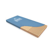 Dynapad Overlay Mattress with blue cover removed, showing beige grooved foam for pressure sore risk, angled view.