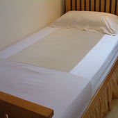 Single bed with Secure Sit & Slide fitted sheet, white bedding, pillow, and wooden headboard against a neutral wall, front view.