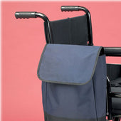 Wheelchair pannier bag attached to a black wheelchair against a pink background, side view.