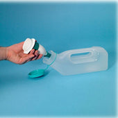 Hand holding a Homecraft male low spill urine bottle adaptor over a male urine bottle with teal cap, close-up view.