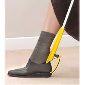 Helping Hand Shoe Helper used to slide brown shoe over grey sock, tool in use, side view.
