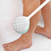 Long handled buff sponge used to wash lower leg and foot, in use during bathing or showering, side view.