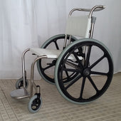 Swimming pool chair with large black wheels, grey tyres, and white seat on tiled floor, side view.